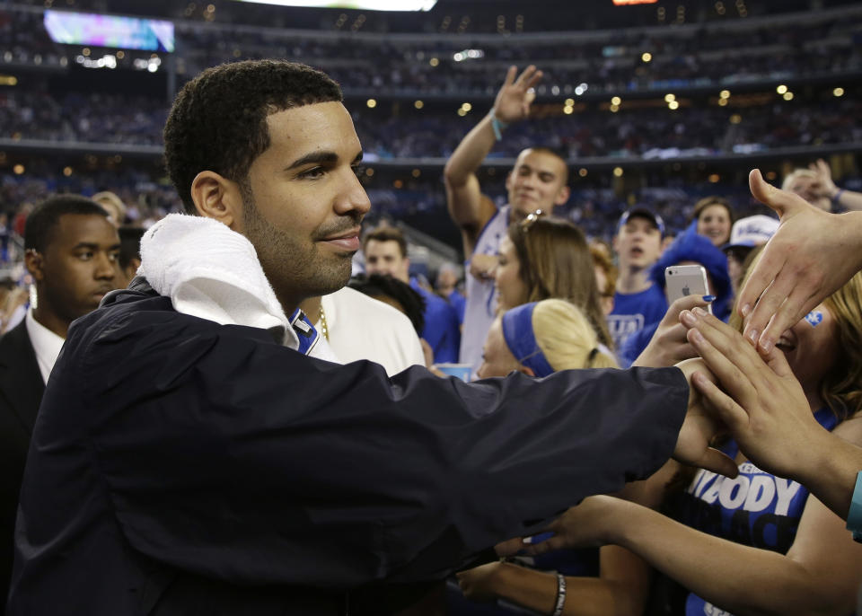 Canadian entertainer Drake greets Kentucky fans during halftime of an NCAA Final Four tournament college basketball semifinal game against Wisconsin Saturday, April 5, 2014, in Arlington, Texas. (AP Photo/David J. Phillip)