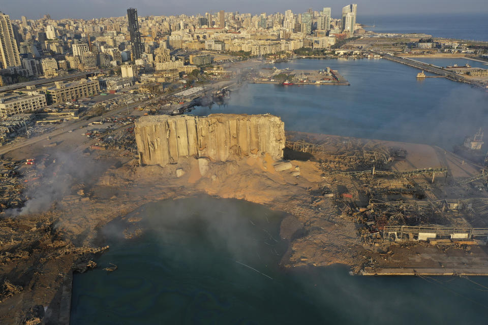 A drone picture shows the scene of an explosion that hit the seaport of Beirut, Lebanon, Wednesday, Aug. 5, 2020. A massive explosion rocked Beirut on Tuesday, flattening much of the city's port, damaging buildings across the capital and sending a giant mushroom cloud into the sky. (AP Photo/Hussein Malla)