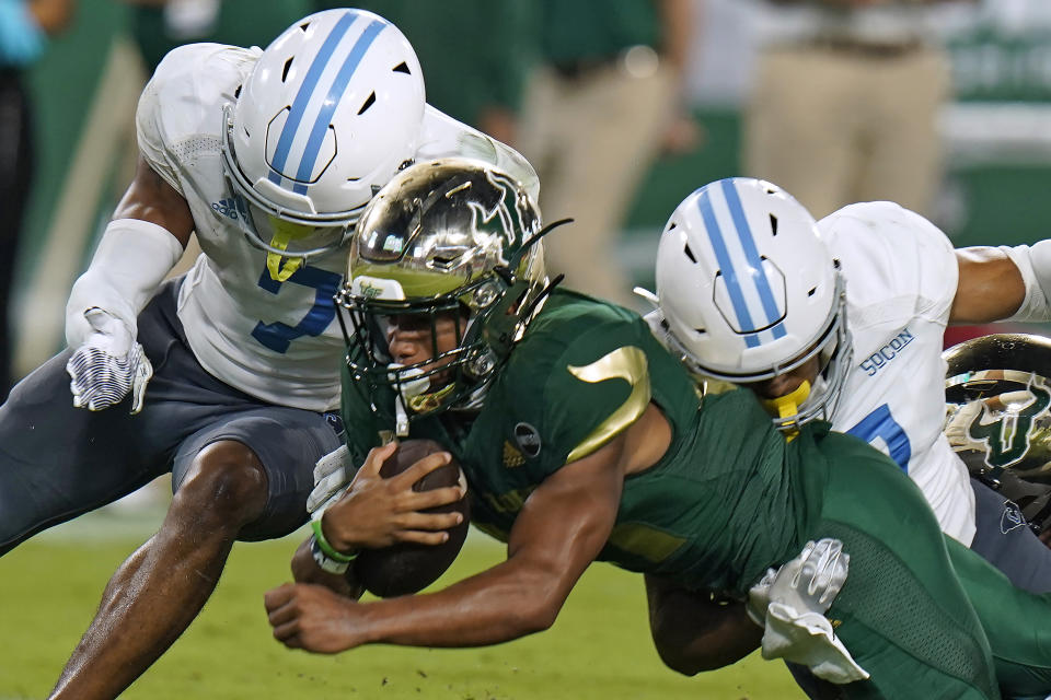 South Florida running back Brian Battie (21) is taken down by Citadel defensive back Destin Mack (7) and defensive back Chris Beverly (17) during the second half of an NCAA college football game Saturday, Sept. 12, 2020, in Tampa, Fla. (AP Photo/Chris O'Meara)