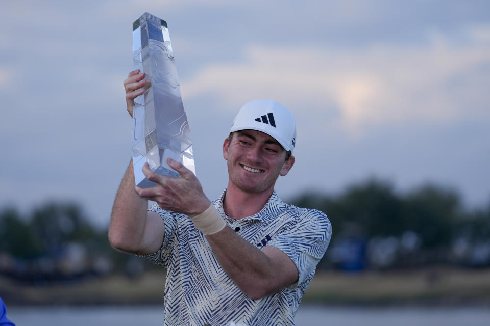 Nick Dunlap holds the trophy after winning the American Express golf tournament, Sunday, Jan. 21, 2024, in La Quinta, Calif. (AP Photo/Ryan Sun)