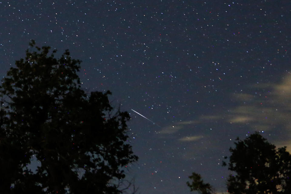 A meteor streaks across the night sky over Lick Observatory during the Perseid meteor shower at Mount Hamilton in California.