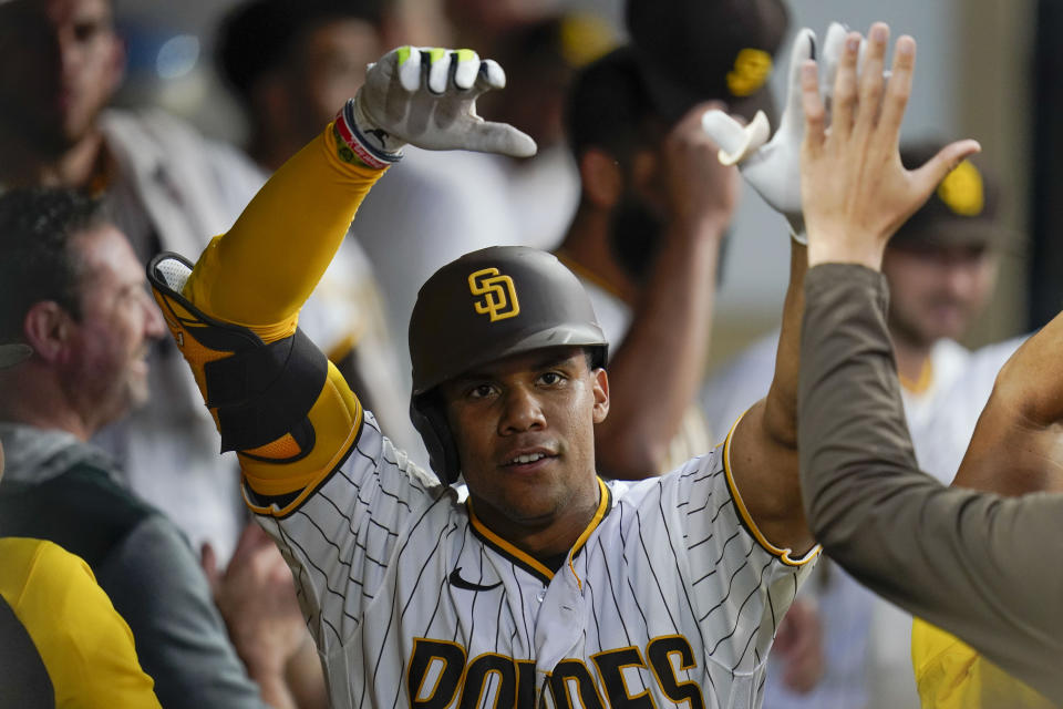 San Diego Padres' Juan Soto celebrates with teammates in the dugout after his home run against the San Francisco Giants during the fourth inning of a baseball game Tuesday, Aug. 9, 2022, in San Diego. (AP Photo/Gregory Bull)