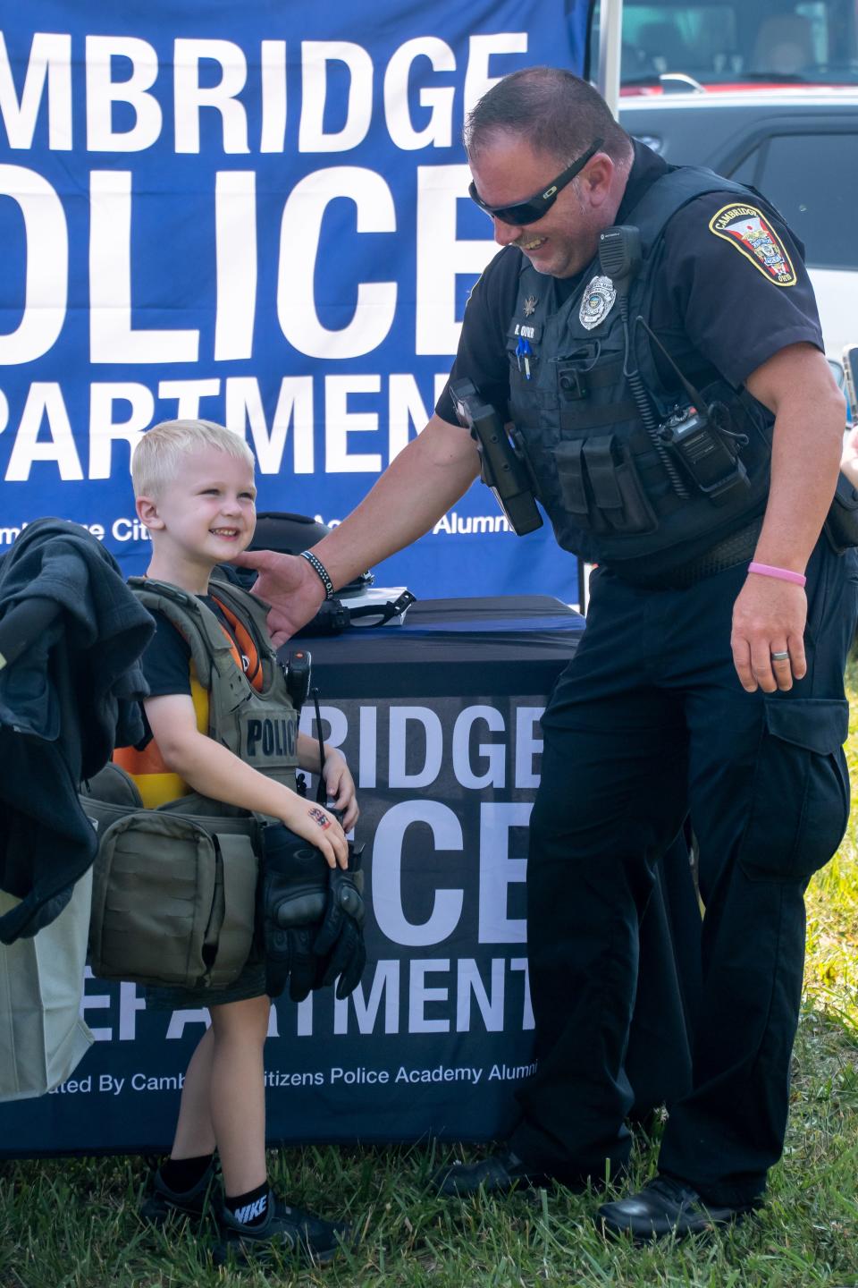 Weston Broom of Byesville hangs out with Ryan Oliver of the Cambridge Police Department at the Touch-a-Truck event.