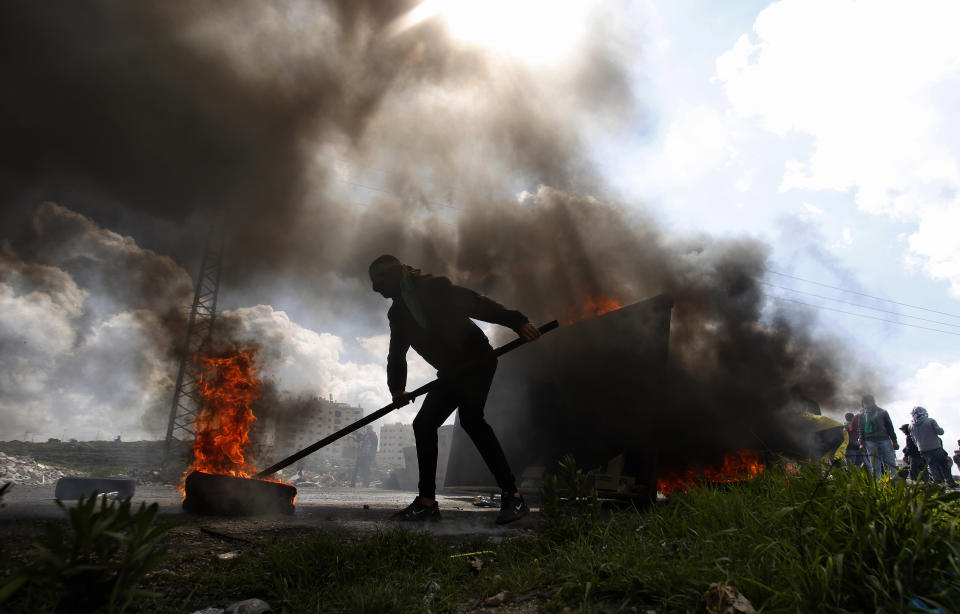 A Palestinian protester burns a tyre during a clashes with Israeli troops during demonstration in support of Palestinian prisoners held in Israeli jails at checkpoint Bet El near the West Bank city of Ramallah , Wednesday, March 27, 2019.(AP Photo/Majdi Mohammed)