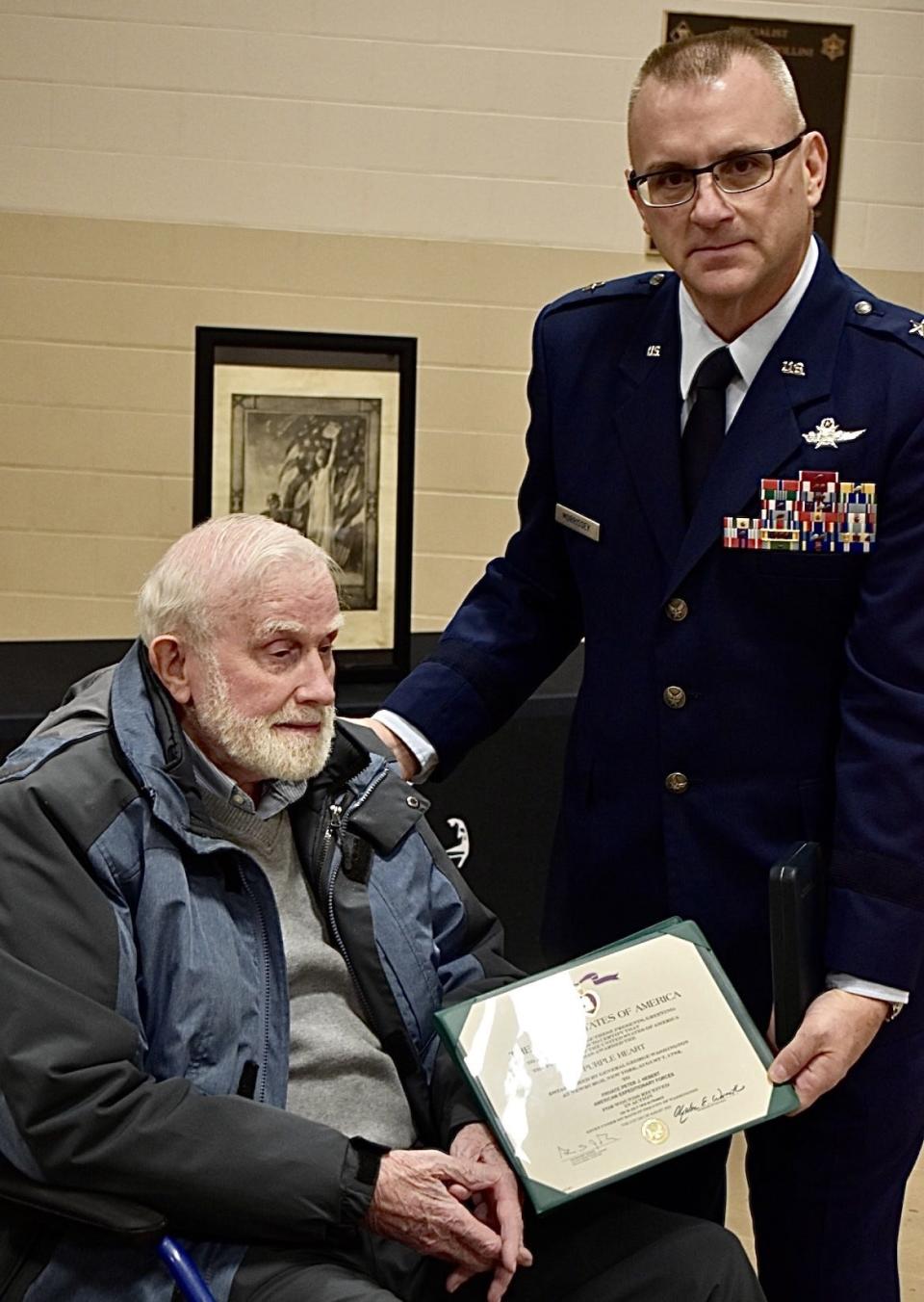 Vincent Hebert, left, is presented with his father's long-overdue Purple Heart in an award presentation ceremony with military dignitaries and elected officials at the Taunton Armory on Honorable Gordon M. Owen Riverway on Friday, Nov. 10, 2023.