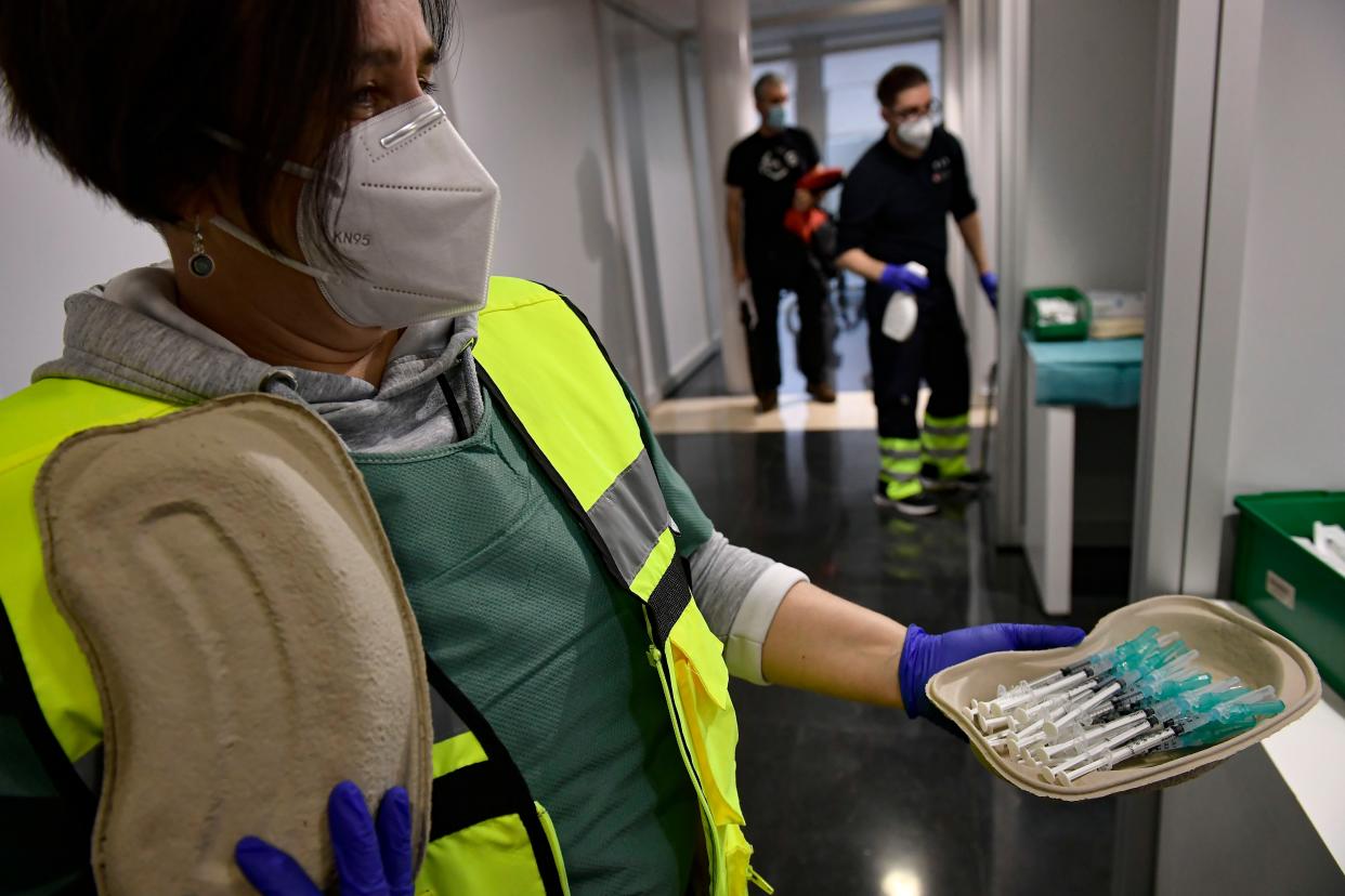 A health staff worker holds some Pfizer coronavirus vaccines before vaccinating health workers in Pamplona, northern Spain, Tuesday, Dec. 29. 2020.