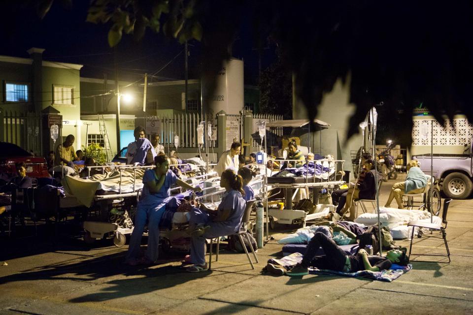 Patients evacuated from a hospital gather in a parking after several earthquakes affected Managua, Nicaragua, Monday, April 14, 2014. The government is recommending people sleep outside after an earthquake occurred a bit further away from Managua Sunday morning, following quakes on Thursday and Friday. (AP Photo/Esteban Felix)