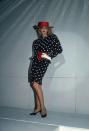 <p>Jerry Hall models a polka-dot dress, red wide-brim hat, and a matching belt.</p>