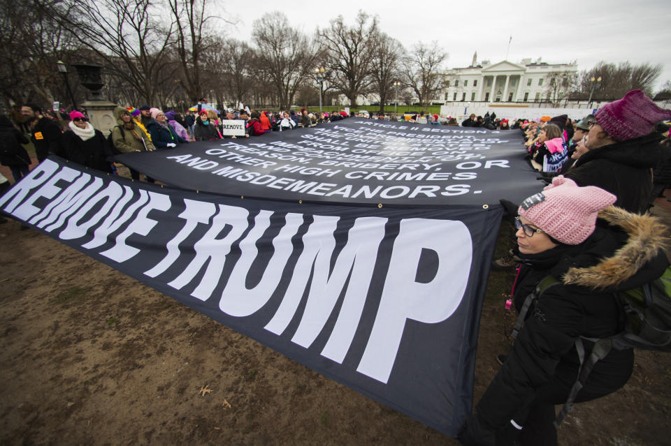 Participants of the Women's March hold banners near the White House, Saturday, Jan. 18, 2020, in Washington, three years after the first march in 2017, the day after President Donald Trump was sworn into office. (AP Photo/Manuel Balce Ceneta)