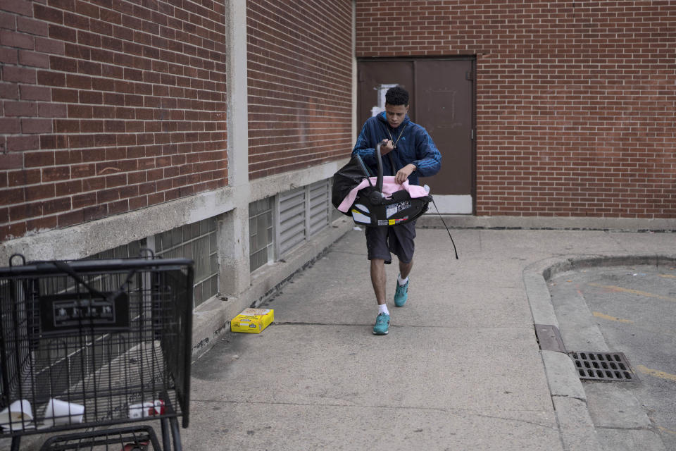 Ronny Reyes, 22, leaves a temporary shelter for migrants at Piotrowski Park with his 5-month-old daughter Magaly Melende, Thursday, March 28, 2024, in Chicago. Piotrowski Park is one of the five shelters for migrants the city of Chicago plans to close in the coming weeks. The city's first step is moving 800 people into other shelters starting Saturday, clearing the park district fieldhouses to resume normal operations for summer. (AP Photo/Erin Hooley)