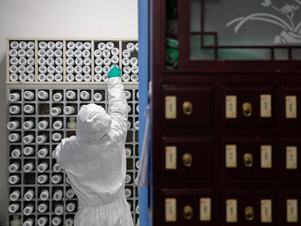 A medical worker in protective suit prepares traditional Chinese medicine (TCM) for patients of the novel coronavirus with an intelligent dispensing equipment at a pharmacy of Wuhan Tongji Hospital in Wuhan, the epicentre of the novel coronavirus outbreak, in Hubei province, China March 2, 2020. China Daily via REUTERS