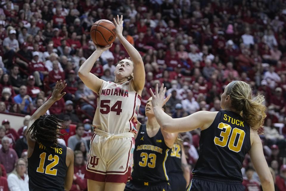 Indiana's Mackenzie Holmes (54) shoots against Michigan's Ari Wiggins (12) and Elise Stuck (30) during the second half of an NCAA college basketball game Thursday, Feb. 16, 2023, in Bloomington, Ind. (AP Photo/Darron Cummings)