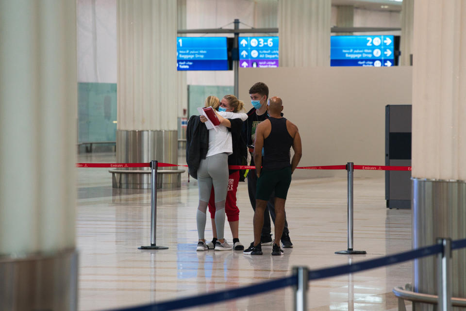 A family says goodbye to each other while wearing masks due to the coronavirus pandemic at Dubai International Airport's Terminal 3 in Dubai, United Arab Emirates, Wednesday, June 10, 2020. The coronavirus pandemic has hit global aviation hard, particularly at Dubai International Airport, the world's busiest for international travel, due to restrictions on global movement over the virus. (AP Photo/Jon Gambrell)