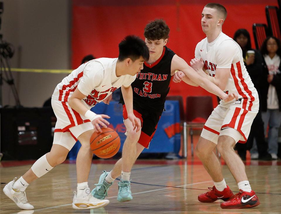Raider Kobe Nguyen makes a move as teammate Zach Taylor tries to block a move by WH guard Drew Daley. North Quincy hosted Whitman-Hanson in MIAA tournament action narrowly beating W-H by one point on a free throw with less than a second to play on Friday March 3, 2023 