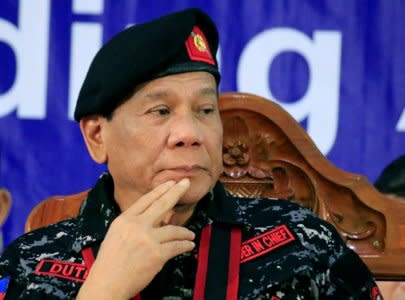 FILE PHOTO: Philippine President Rodrigo Duterte, wearing a military uniform, gestures as he attends the 67th founding anniversary of the First Scout Ranger regiment in San Miguel town, Bulacan province, north of Manila, Philippines November 24, 2017.        REUTERS/Romeo Ranoco