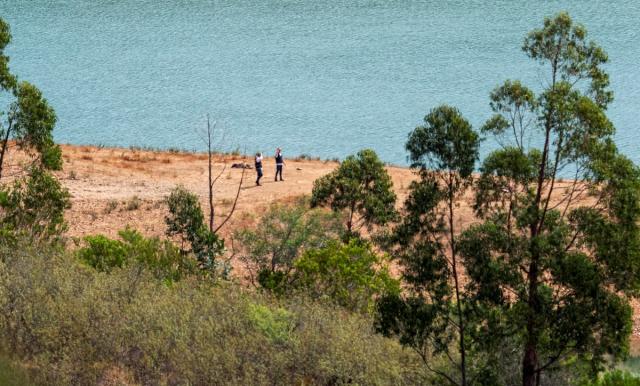 Officers at the dam where the search is set to begin on Tuesday (REUTERS)