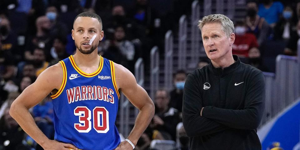 Stephen Curry and Steve Kerr stand next to each other during a game.