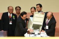 Hong Kong chief executive candidate Woo Kwok-hing (L) watches the vote-counting process during the election