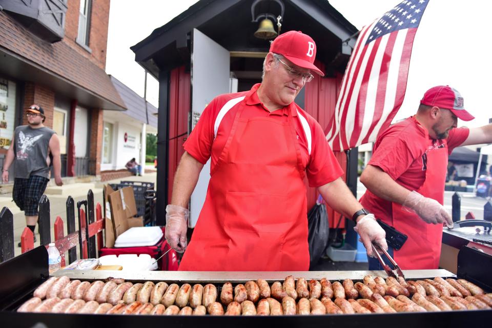 Tim Souder, assistant principal of Bucyrus High School, flips a row of sausages Thursday morning during the 2023 Bucyrus Bratwurst Festival.