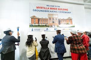 Howard University administrators ceremoniously punch through the wall of the historic Myrtilla Miner Building