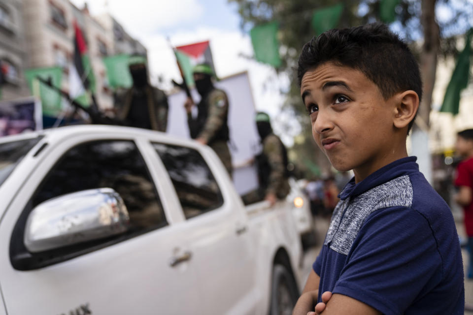 A child watches as Hamas militants parade through the streets for Bassem Issa, a top Hamas' commander, who was killed by Israeli Defense Force military actions prior to a cease-fire reached after an 11-day war between Gaza's Hamas rulers and Israel, in Gaza City, Saturday, May 22, 2021. (AP Photo/John Minchillo)