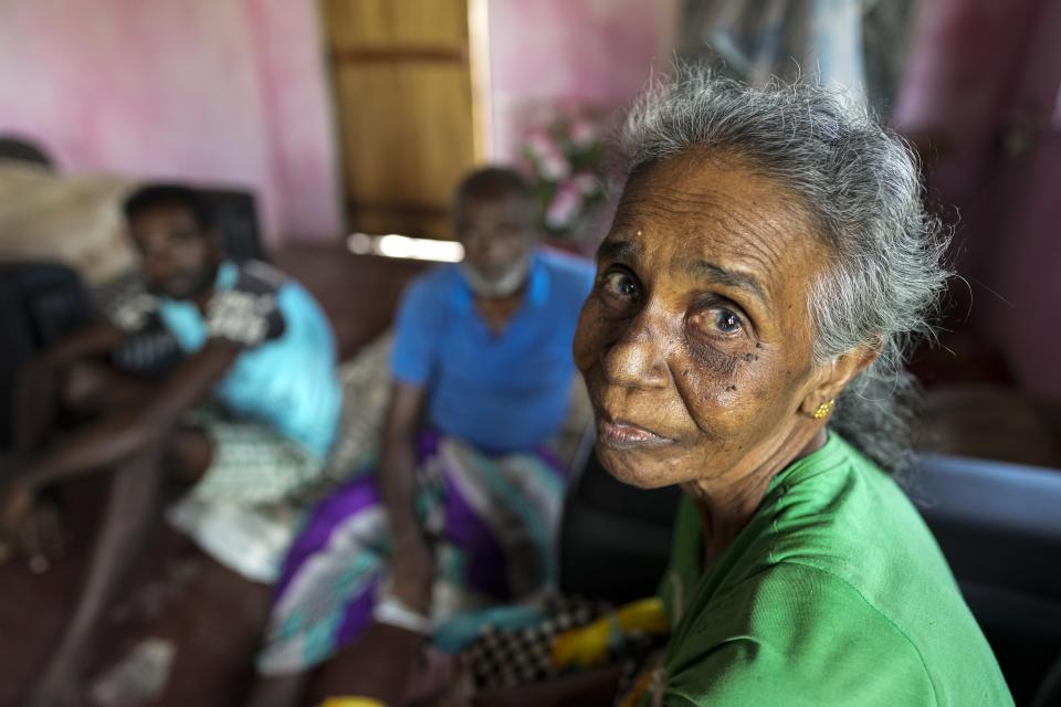 Jassintha, the wife of Ranjith Sunimal Fernando, sits at their temporary dwelling in Iranawila, Sri Lanka, Friday, June 16, 2023. Much like the hundreds of other fishing hamlets that dot the coastline, the village of Iranawila suffers from coastal erosion. (AP Photo/Eranga Jayawardena)