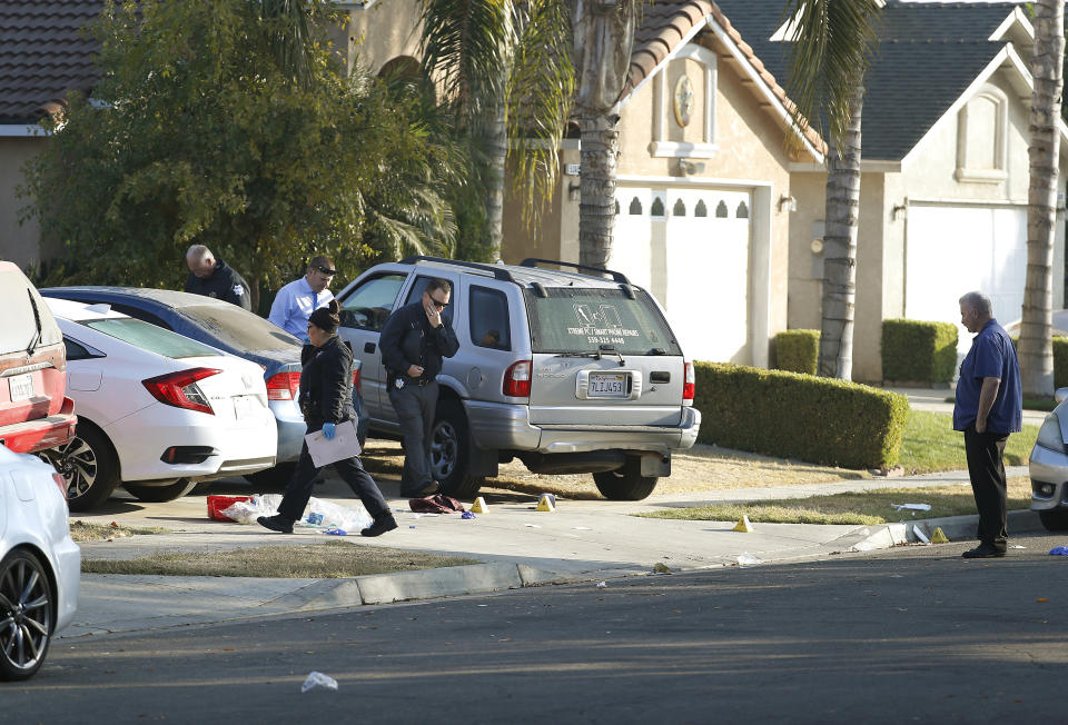 Fresno police investigators work the driveway where a shooting took place at a house party which involved multiple fatalities and injuries in Fresno, Calif., Monday, Nov. 18, 2019. (AP Photo/Gary Kazanjian)