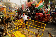 NEW DELHI, INDIA - JANUARY 26 : Indian Farmers attempt to break a barricade farmers who marched to the capital during India's Republic Day celebrations in New Delhi on India January 26, 2021, The thousands of farmers drove a convoy of tractors into the Indian capital as the nation celebrated Republic Day on Tuesday in the backdrop of agricultural protests that have grown into a rebellion and rattled the government. (Photo by Imtiyaz Khan/Anadolu Agency via Getty Images)