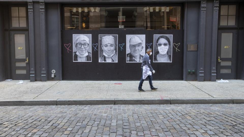 Ein Mann mit Mundschutz geht an einer geschlossenen Boutique in New York vorbei.