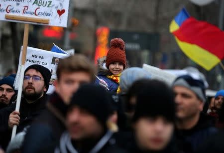 A child attends a demonstration in Bucharest, Romania, February 4, 2017. REUTERS/Stoyan Nenov