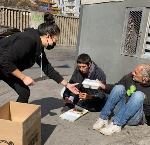 Cindy Ha handing out prepared meals to Montrealers paid for with the proceeds of her homemade mask sales.