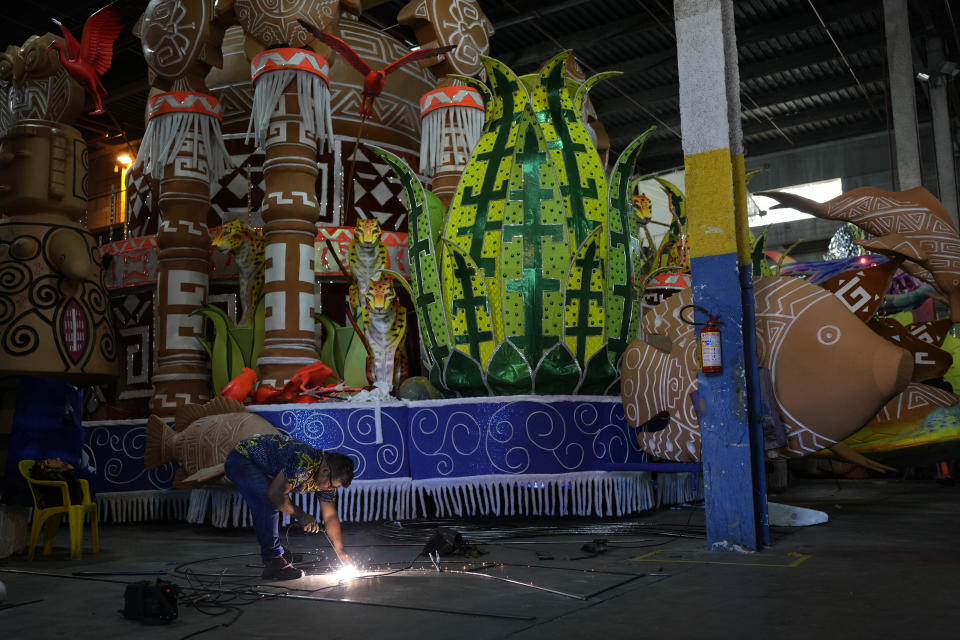 A worker from the Paraiso do Tuiuti samba school, welds a frame for a float at the Samba City complex in Rio de Janeiro, Brazil, Thursday, Feb. 9, 2023. Samba schools are already gearing up for next Carnival, building the colorful floats and stitching together the costumes. (AP Photo/Silvia Izquierdo)