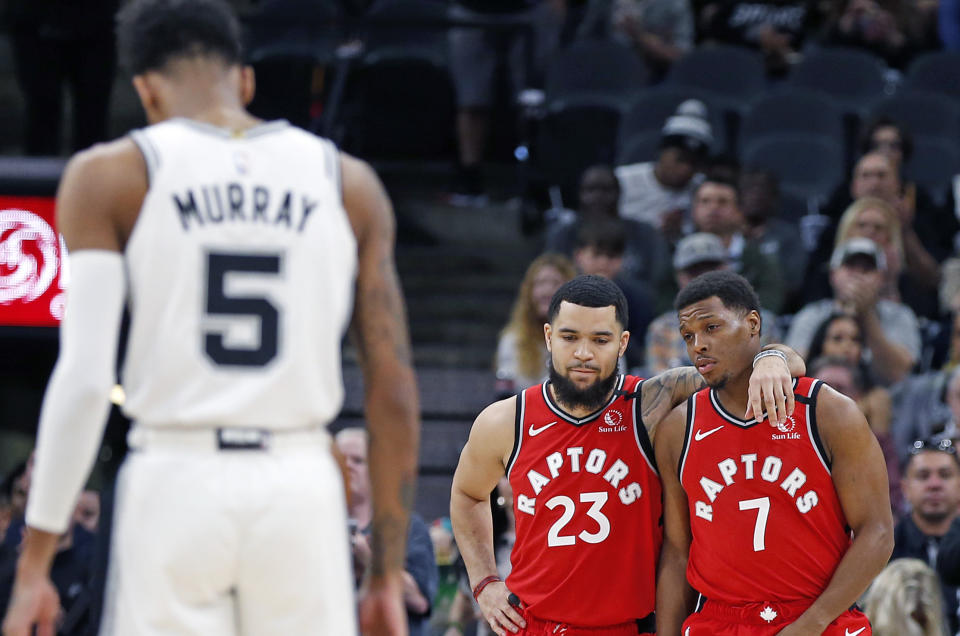 SAN ANTONIO, TX - JANUARY 26:  After the first two possessions both teams took planned turnovers as the crowd chanted "KOBE" as Fred VanVleet #23 of the Toronto Raptors and Kyle Lowry #7 embrace as Dejounte Murray #5 of the San Antonio Spurs takes a moment during first half action at AT&T Center on January 26, 2020 in San Antonio, Texas.  NOTE TO USER: User expressly acknowledges and agrees that ,by downloading and or using this photograph, User is consenting to the terms and conditions of the Getty Images License Agreement. (Photo by Ronald Cortes/Getty Images)