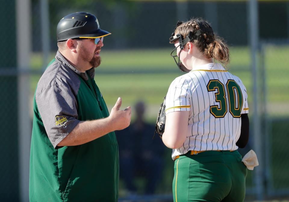 Freedom coach Tim Dietzen talks with pitcher Peyton VandeLoo (30) during their Division 2 regional softball final last May in Freedom.