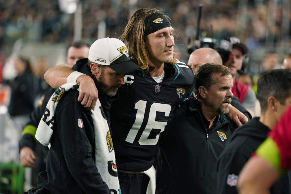 Jacksonville Jaguars quarterback Trevor Lawrence (16) is assisted off the field after he was injured during the second half of an NFL football game against the Cincinnati Bengals, Monday, Dec. 4, 2023, in Jacksonville, Fla. (AP Photo/John Raoux)