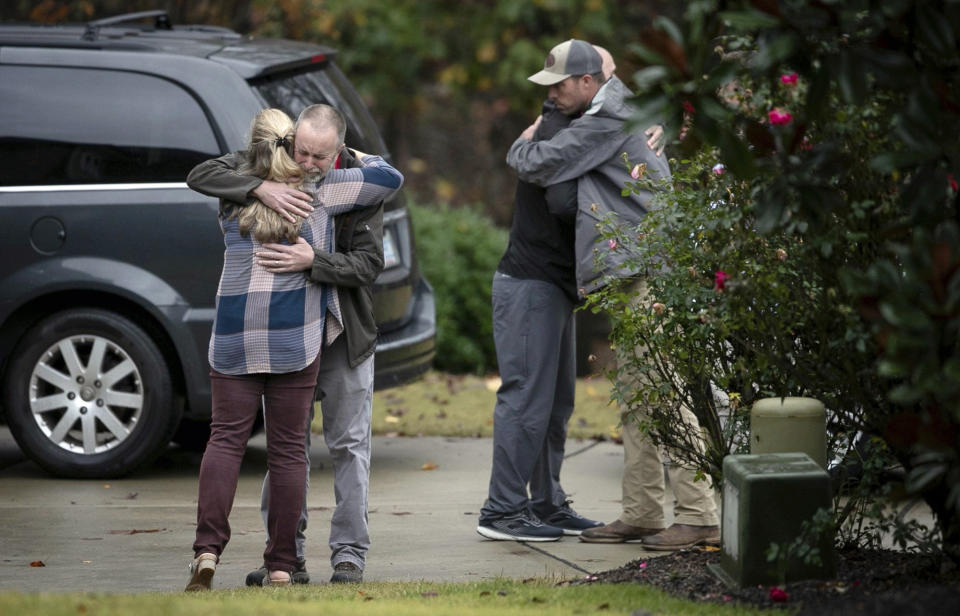 Neighbors console each other on Lord Granville Way in Rolesville, N.C., on Thursday, Nov. 12, 2020, after a neighborhood child drowned in a nearby flooded creek following heavy rains, according to The News & Observer. (Robert Willett/The News & Observer via AP)
