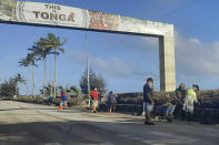 In this photo provided by Broadcom Broadcasting, people clear debris off the street in Nuku'alofa, Tonga, Thursday, Jan. 20, 2022, following Saturday's volcanic eruption near the Pacific archipelago. The first flight carrying fresh water and other aid to Tonga was finally able to leave Thursday after the Pacific nation's main airport runway was cleared of ash left by the eruption. (Marian Kupu/Broadcom Broadcasting via AP)