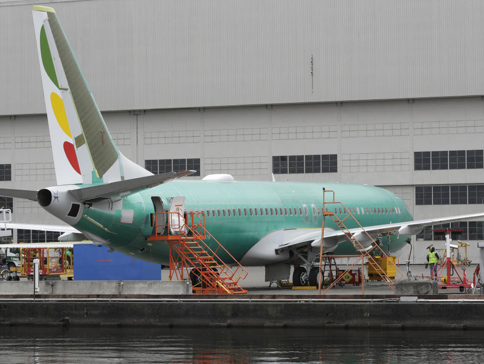 A worker stands near a Boeing 737 MAX 8 airplane parked at Boeing Co.'s Renton Assembly Plant, Monday, March 11, 2019, in Renton, Wash. Airlines in several countries grounded the same model jetliner Monday following Sunday's crash of an Ethiopian Airlines Boeing 737 Max 8, the second devastating crash of one of the planes in five months. (AP Photo/Ted S. Warren)