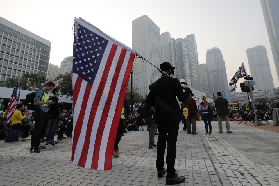 A protester holds U.S flag during a rally to show support for Uighurs and their fight for human rights in Hong Kong, Sunday, Dec. 22, 2019. Thousands of demonstrators attended a rally to protest against China's policy about Uighur minority. (AP Photo/Lee Jin-man)