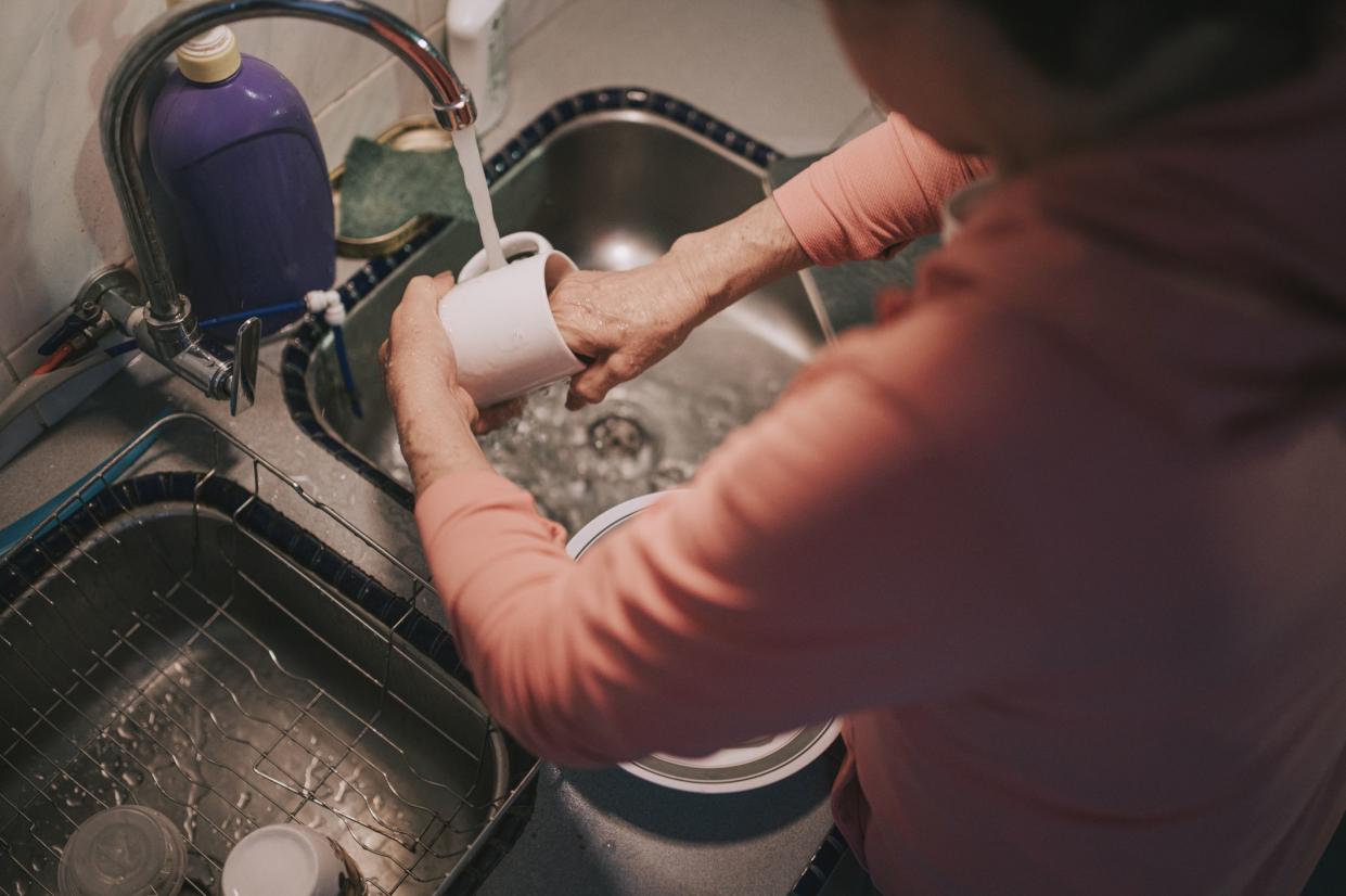 top view asian senior woman washing dishes cup after dinner at kitchen