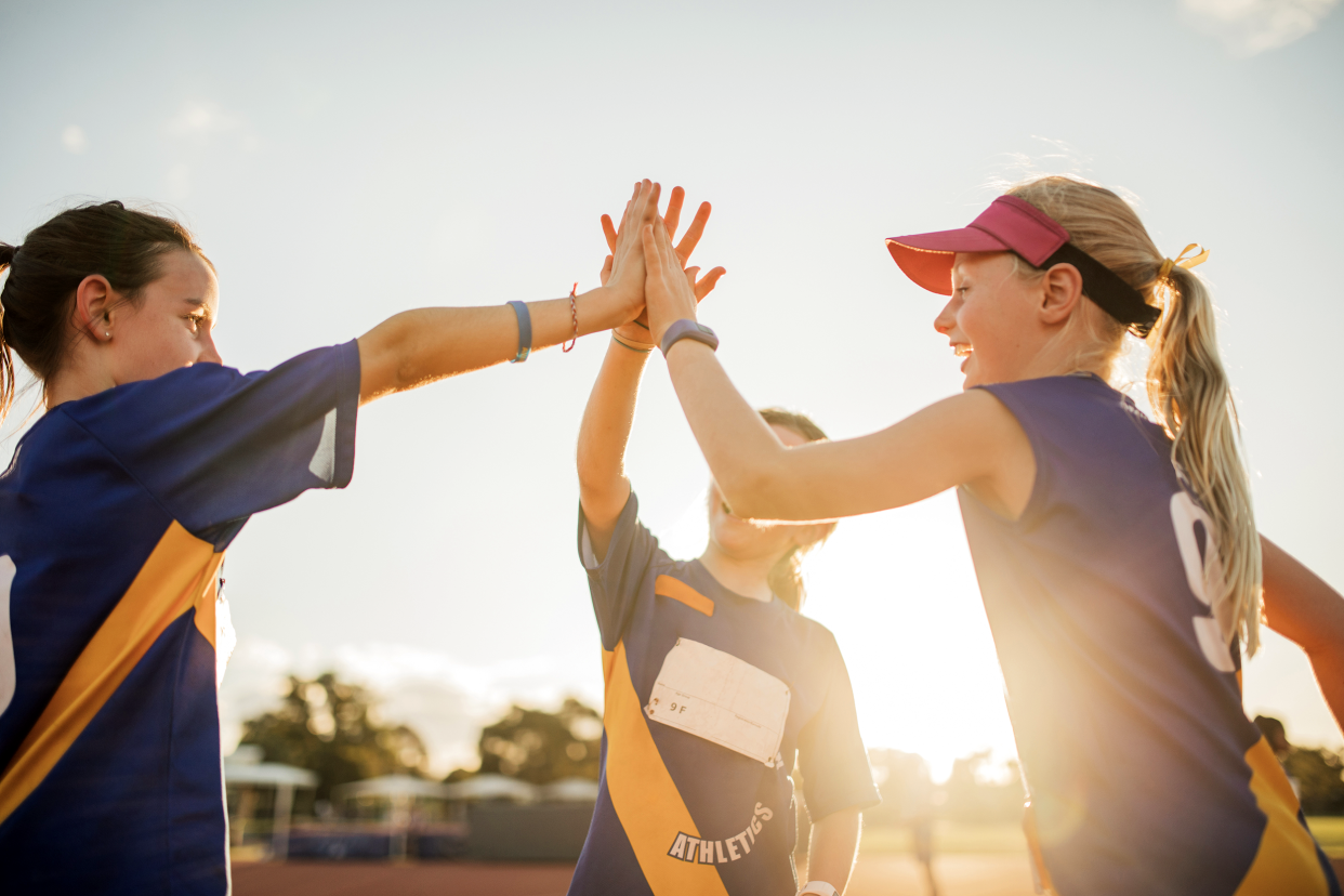 Girls on a sports team giving each other a high five