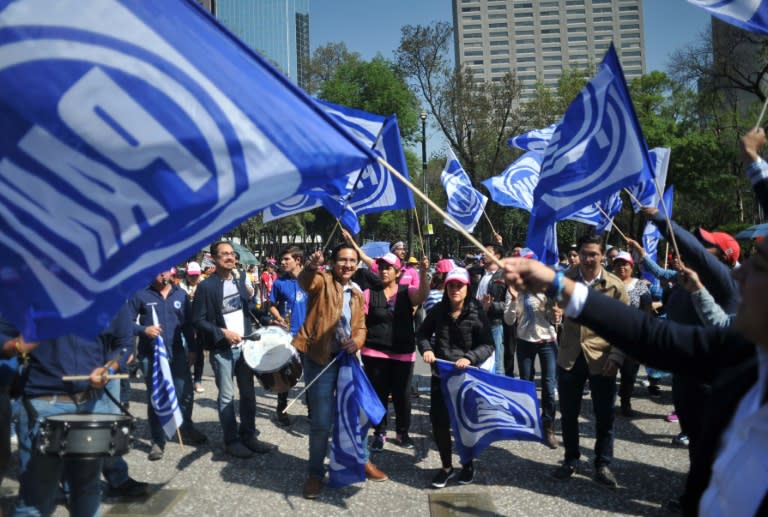 Supporters of Ricardo Anaya wave National Action Party (PAN) flags as they arrive for the official announcement of his presidential candidacy at the national auditorium on February 18, 2018, in Mexico City