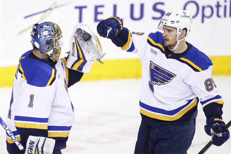 St. Louis Blues goalie Thomas Greiss, is congratulated by Pavel Buchnevich after defeating the Calgary Flames in NHL hockey game action in Calgary, Alberta, Friday, Dec. 16, 2022. (Larry MacDougal/The Canadian Press via AP)