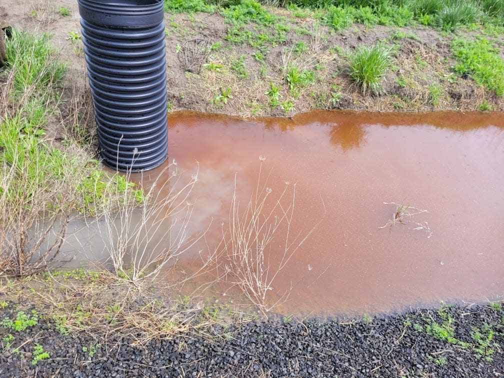 An unknown red substance is flowing through drainage ditches following a fire at 7560 Perrydale Loop.