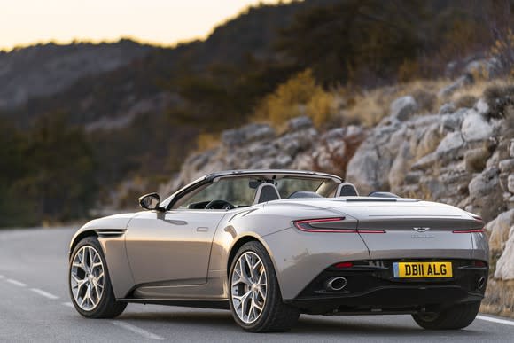 A silver Aston Martin DB11 Volante, a sleek luxury-sports convertible, shown from a rear three-quarter view.