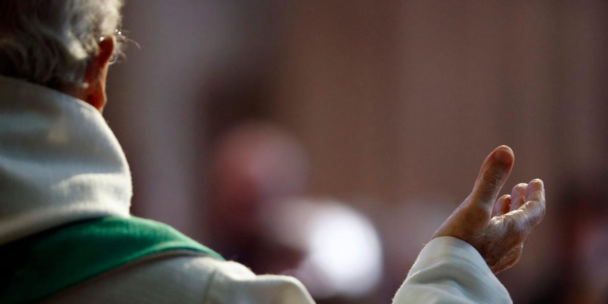 A stock image shows a priest delivering a service.