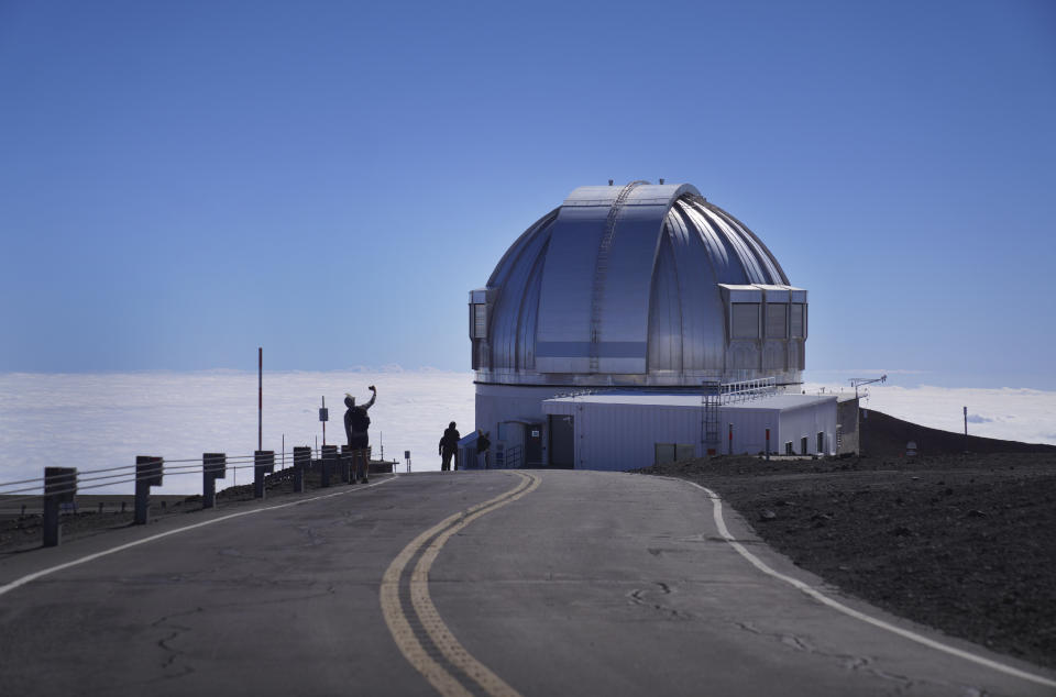 Visitors take photos near an observatory on the summit of Mauna Kea in Hawaii, on Saturday, July 15, 2023. Over the last 50 years, astronomers have mounted 13 giant telescopes on Mauna Kea's summit. In 2009, they proposed an even larger Thirty Meter Telescope, which spurred lawsuits and protests by Native Hawaiian activists. (AP Photo/Jessie Wardarski)