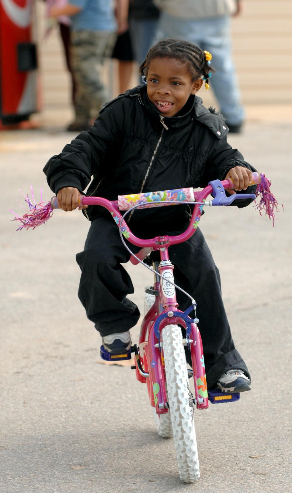 Larickya Cummings, 6, rides her new bike away from the 25th annual J.P. Hall Christmas Party in 2006. There were around 500 new and refurbished bikes donated by several groups to be given away at the Clay County charity event.