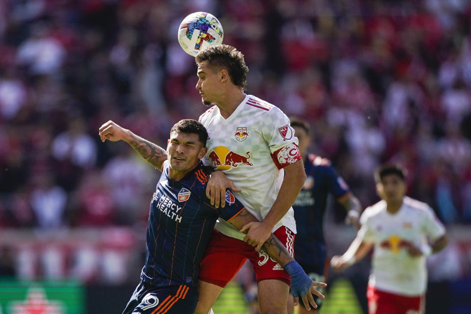 New York Red Bulls defender Aaron Long, right heads the ball over FC Cincinnati forward Brandon Vazquez (19) during an MLS playoff soccer match, Saturday, Oct. 15, 2022, in Harrison, N.J. (AP Photo/Eduardo Munoz Alvarez)