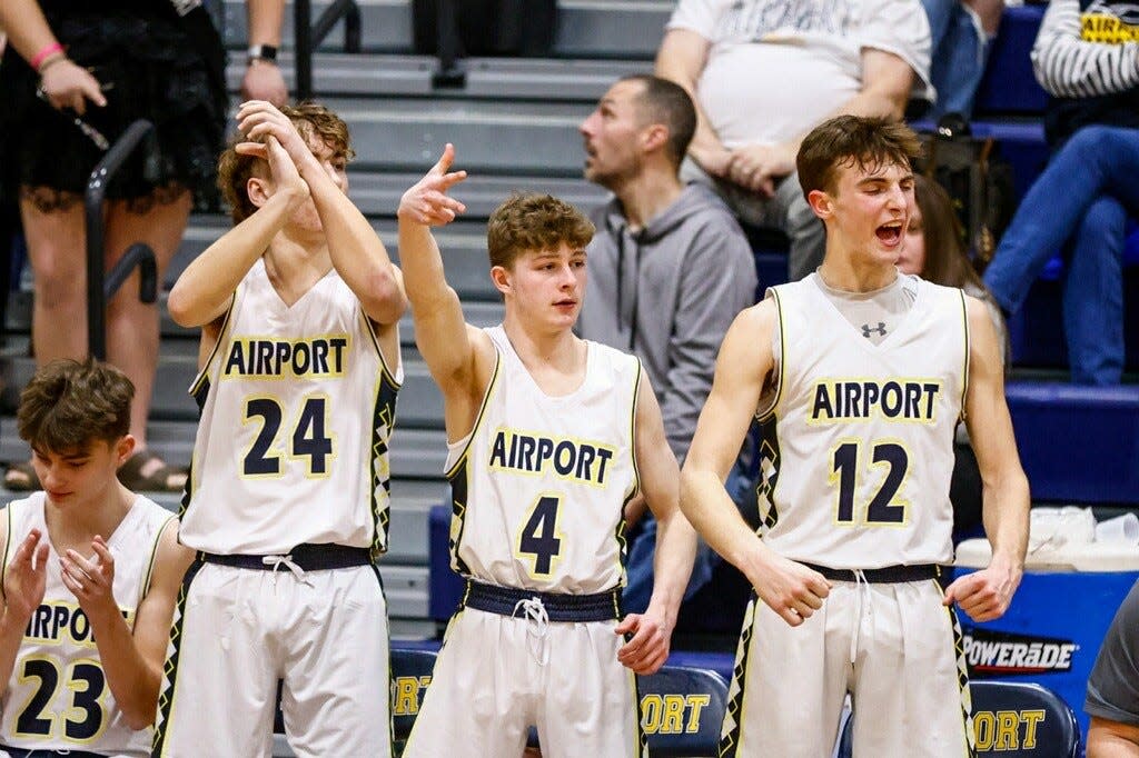 Drake Ferris (24), Lance Choike (4) and Aidyn Stahr (12) react on the Airport bench during a game against Flat Rock on Friday, Feb. 2, 2024.